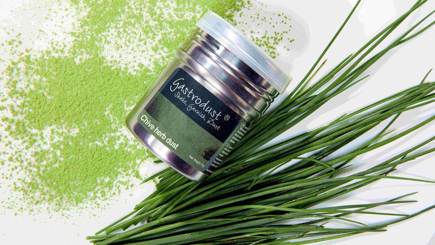 tub of chive gastrodust with sprigs of chive